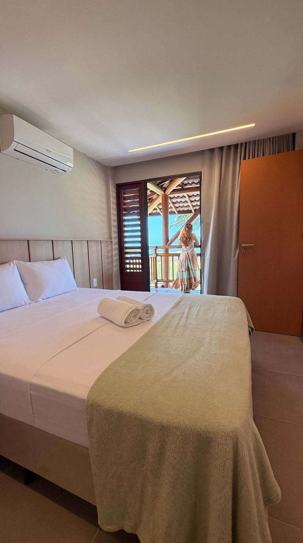 Suíte com cama de casal, ar-condicionado e cortinas